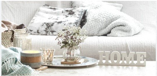 a table with a vase of flowers on it and a couch in the background